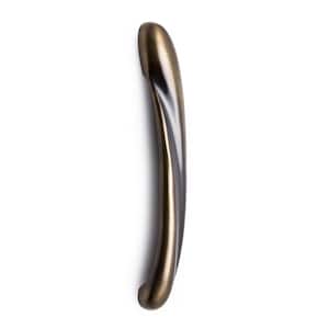 May include: A curved, bronze-colored door handle against a white background. The handle has a smooth, polished finish and a slightly arched shape, with a rounded end and a subtle curve along its length. The metal has a warm, antique appearance.