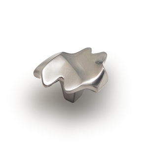 May include: A silver, abstractly shaped cabinet knob with a textured finish.