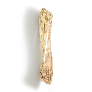 Pode incluir: Uma maçaneta de porta de metal texturizado em ouro e bronze com um design único e retorcido.