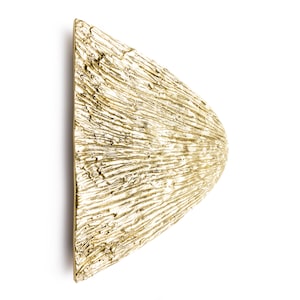 May include: A gold-coloured, triangular wall sconce with a textured surface. The sconce has a unique, organic shape and a modern design.