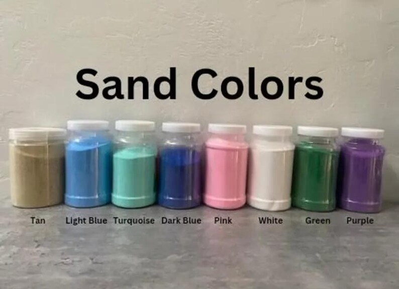 May include: A collection of eight clear plastic jars filled with colored sand. The sand colors include tan, light blue, turquoise, dark blue, pink, white, green, and purple. The text "Sand Colors" is displayed above the jars.