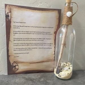May include: A clear glass bottle with a cork stopper, twine, and a seashell decoration. Inside the bottle are sand, seashells, and a rolled-up scroll. A printed scroll with text is next to the bottle.