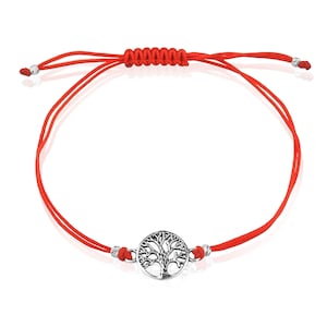 May include: Red string bracelet featuring a silver-colored tree of life charm. The bracelet has adjustable sliding knots and small silver beads at the ends. The tree of life charm is a detailed, circular design.