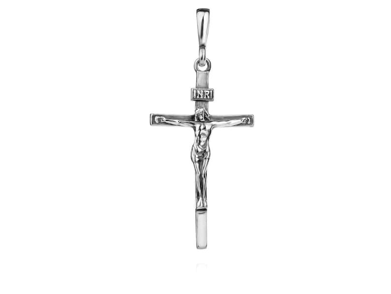 Puede incluir: Pendiente de plata en forma de crucifijo con una figura detallada de Jesucristo en la cruz. La inscripci&oacute;n "INRI" es visible en la cruz.
