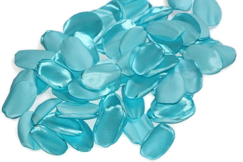 May include: A pile of teal blue satin rose petals. The petals are soft and silky, and they would be perfect for a wedding or other special event.