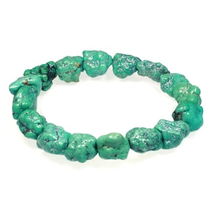 May include: A turquoise gemstone bracelet featuring irregularly shaped beads. The bracelet is crafted from natural turquoise stones, each with a distinctive shape and size. The stones are a vibrant green colour with brown veins running through them.