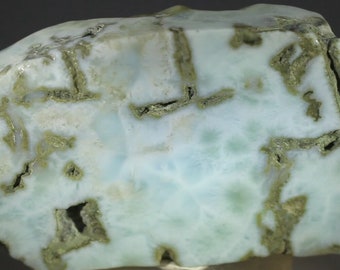 May include: A large, light blue and green rock with a rough, textured surface. The rock has a unique pattern of white and green veins.