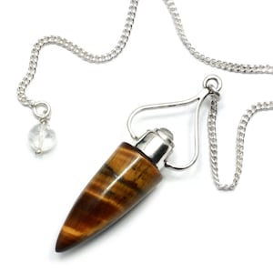 May include: A brown and gold tiger's eye crystal pendulum with a silver chain and a clear crystal at the end of the chain.
