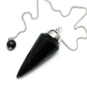 Puede incluir: Pendulo de obsidiana negra con una cadena de plata y una cuenta de plata en el extremo. El péndulo tiene forma de cono y tiene una superficie lisa y pulida.