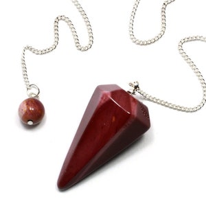 May include: A red gemstone pendulum with a silver chain and a smaller red gemstone bead at the end of the chain.