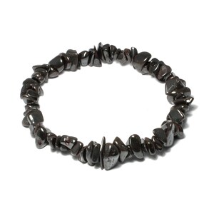 May include: A black hematite chip bracelet made of small, irregular shaped stones. The bracelet is made of natural hematite and is designed to be worn on the wrist.