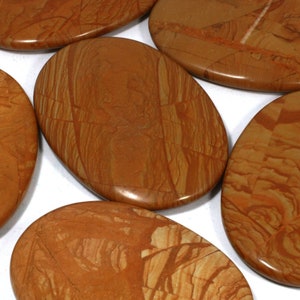 Peut inclure: Cinq pierres lisses de forme ovale avec un motif marbré brun et orange. Les pierres sont polies et ont une finition brillante.