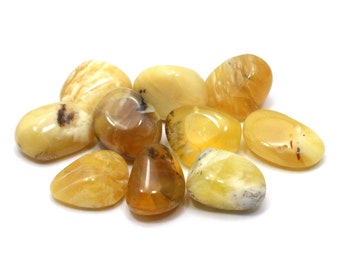 May include: A collection of yellow and brown tumbled opal stones. The stones are smooth and polished, with a variety of shapes and sizes.