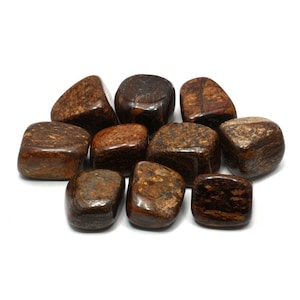 May include: A collection of ten tumbled brown and gold tiger iron stones. The stones are smooth and polished, with a variety of patterns and textures.