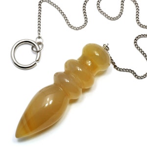 Può includere: Un pendolo di cristallo sfaccettato color oro dorato con una catena e un anello argentati.