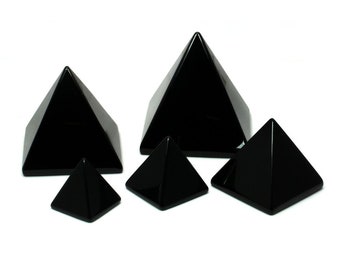 May include: Set of five black obsidian pyramids of varying sizes. The pyramids are smooth and polished.