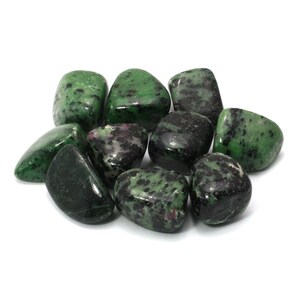 Puede incluir: Una colección de piedras pulidas verdes y negras. Las piedras son lisas y pulidas, con una variedad de patrones y texturas.