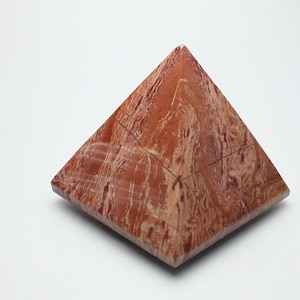 May include: A red and white marbled pyramid shaped stone.