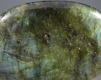 May include: A smooth, oval-shaped green labradorite gemstone with iridescent flashes of blue and green.