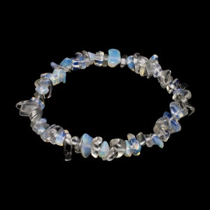 Pode incluir: Um bracelete feito de pequenas pedras de opala irregulares, transparentes e azuis.