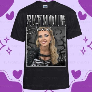 Puede incluir: Camiseta negra con un retrato de una mujer rubia, el nombre "SEYMOUR Jane" en un marco blanco. La camiseta es de estilo cuello redondo clásico, adecuada para uso casual.