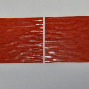 May include: Two rectangular pieces of orange, translucent, textured plastic.