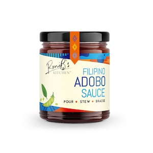 May include: A glass jar of Filipino Adobo Sauce with a colorful label featuring the text "Roni's Kitchen" and "Filipino Adobo Sauce". The label also includes the words "Pour, Stew, Braise".