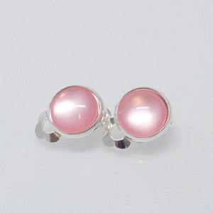 Könnte beinhalten: Ein Paar silberne Ohrringe mit runden rosa Steinen.