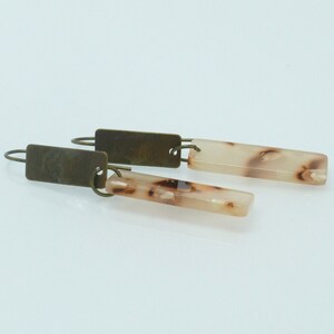 Op de afbeelding: Een paar oorhangers met een rechthoekige, marmeren hanger in bruin en wit en een messing haak.