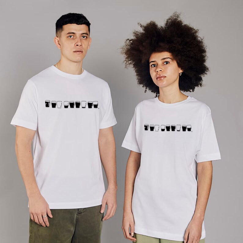 May include: Two people wearing white t-shirts with a black graphic of a row of glasses. The graphic is a simple line drawing of glasses with different levels of liquid.