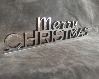 Può includere: Un cartello in metallo argentato con le parole "Merry Christmas" in uno stile 3D a strati.