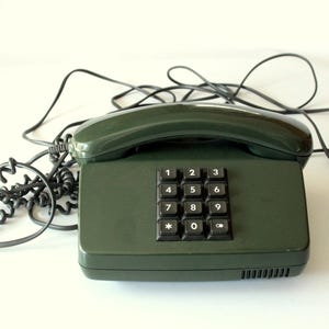 Vintage telefoon met knoppen, drukknoptelefoon donkergroen midden jaren 80, volledig functioneel, rekwisietfilm, retro