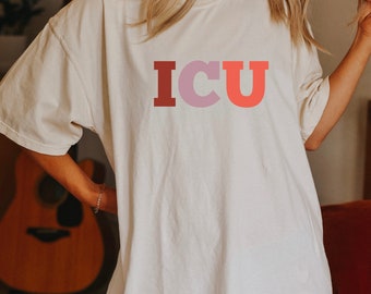 May include: A white oversized t-shirt with the word "ICU" printed in red, pink, and orange letters.