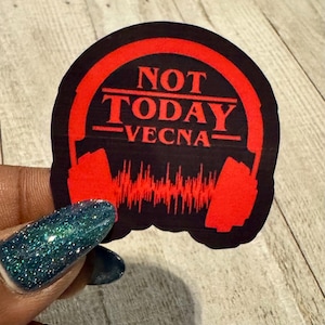 May include: A black and red sticker with the text "NOT TODAY VECNA" in a bold font. The design includes red headphones and a sound wave graphic, creating a striking visual.