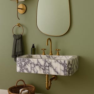 Pu&ograve; includere: Scena di bagno con lavabo in marmo, rubinetti dorati e specchio. Lampada da parete e portasciugamani visibili. Cesto in vimini sotto il lavabo. Il muro &egrave; verde.