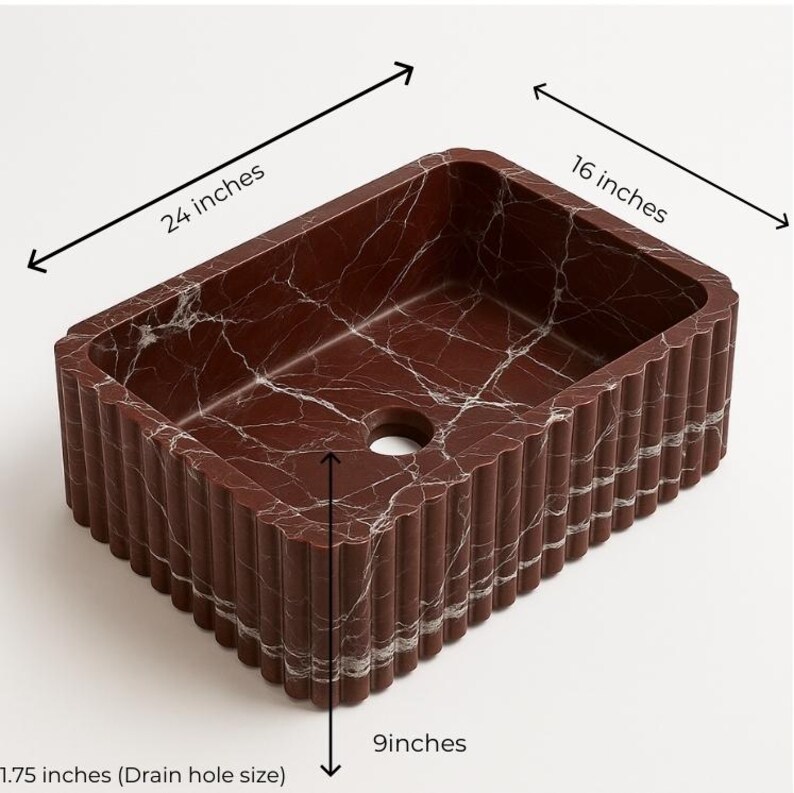May include: A rectangular, burgundy marble sink with white veining. The sink measures 24 inches long, 16 inches wide, and 9 inches deep. The drain hole is 1.75 inches in diameter. The exterior features a ribbed design.