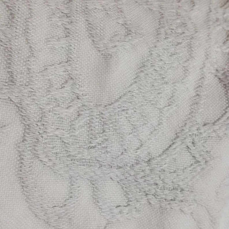 Pu&ograve; includere: Tessuto bianco con un motivo tessuto testurizzato. Il tessuto presenta un design goffrato sottile che ricorda una serie di cerchi sovrapposti.