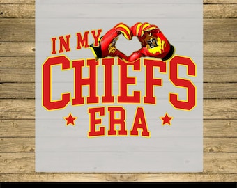May include: Red and yellow graphic with the text "In My Chiefs Era" and a red and yellow hand making a heart shape.