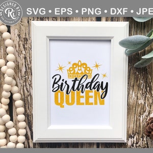 May include: White framed print featuring the text "Birthday QUEEN" in black and gold, with a gold crown and stars. The image is set against a backdrop of wooden textures and decorative elements.