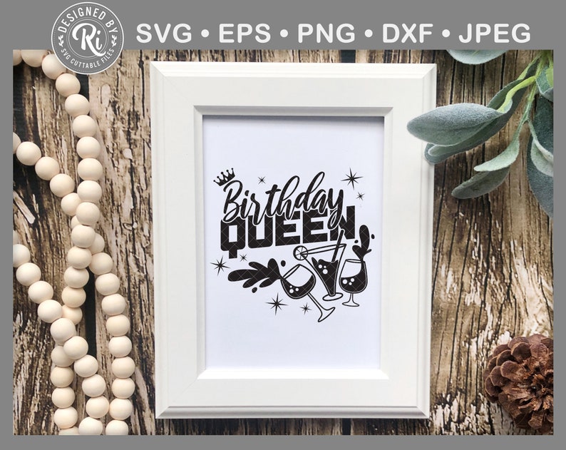May include: A white framed print with black text that reads "Birthday Queen" with a crown above the word "Birthday" and a graphic of three martini glasses with a splash of liquid coming from one of the glasses.