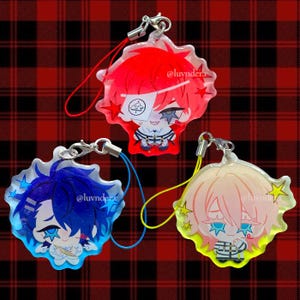 May include: Three acrylic charms featuring stylized anime-style characters with star-shaped accents. One charm has red hair and a white eye patch, one has blue hair, and one has light pink hair. Each includes a colored lanyard and the text @luvnder.r.