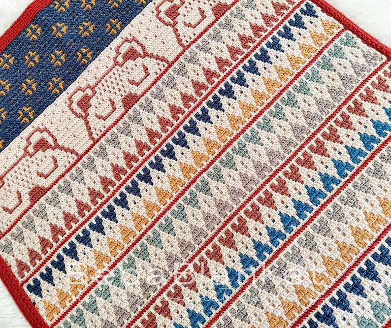 May include: A crocheted blanket with a geometric pattern in shades of red, blue, yellow, and white.