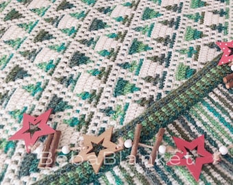 May include: A handmade crochet blanket in shades of white, green, and teal, with a textured pattern. The blanket is decorated with wooden star ornaments and cinnamon sticks. The text "Beba Blanket" is visible on the blanket.