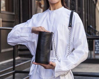 Black genuine leather cylinder shoulder bag with chain strap.