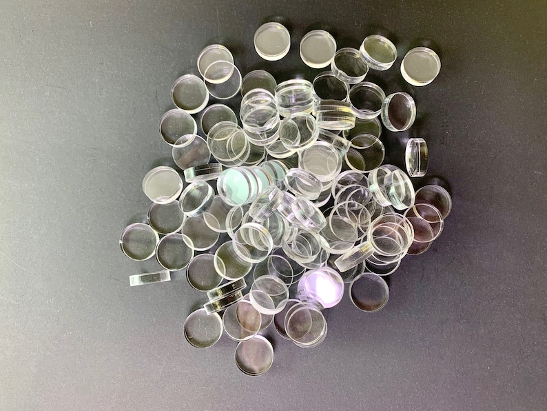 May include: A large pile of clear glass round discs, possibly for crafts or game pieces.