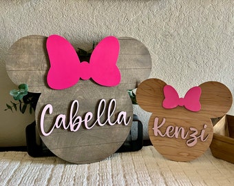 Añade un toque mágico a la habitación de tus hijos con nuestro letrero personalizado con la cabeza de Mickey o Minnie.