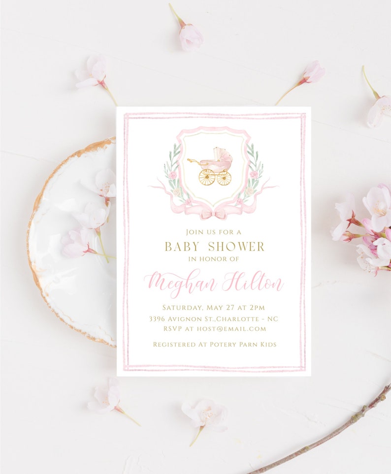 May include: Pink baby shower invitation with a gold and white carriage illustration, gold text, and a pink and white ribbon. The text reads "Join us for a Baby Shower in honor of Meghan Hillon. Saturday, May 27 at 2PM 3396 Avigon St., Charlotte, NC RSVP at host@email.com Registered at Pottery Barn Kids"