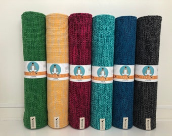 May include: Six rolled yoga mats in green, yellow, magenta, teal, blue, and charcoal grey. Each mat features a white paper band with the text TEXDUD, a graphic of a person in a lotus pose, and the words Yoga Mat and 100% Natural Cotton.