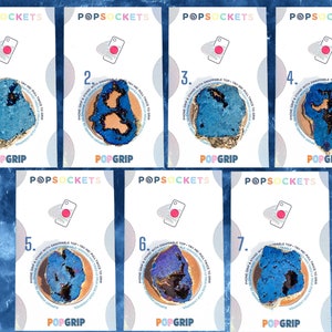Könnte beinhalten: Sieben verschiedene Handy-Griffdesigns mit einem blauen und goldenen Achatmuster. Jedes Design ist von 1 bis 7 nummeriert. Die Handygriffe sind alle weiß mit dem aufgedruckten Text "POPSOCKETS" und "POPGRIP".