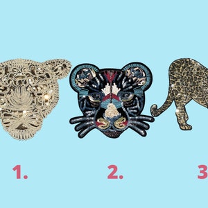 Può includere: Tre toppe da stirare ricamate con diversi stili di design di leopardo. La prima toppa è una testa di leopardo bianca e dorata. La seconda toppa è una testa di leopardo nera, blu e rossa. La terza toppa è un leopardo marrone e dorato con un motivo a macchie.